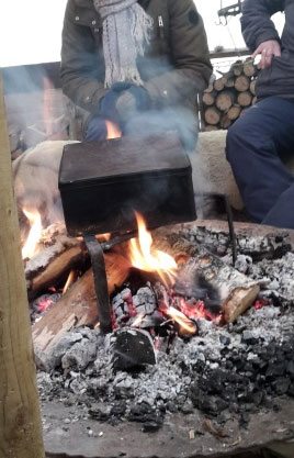 Herstellung von Kohle- Zeichenstiften aus Weidenästen: Frische Weidenäste in eine Blechdose gelegt und über dem offenen Feuer abgebrannt.